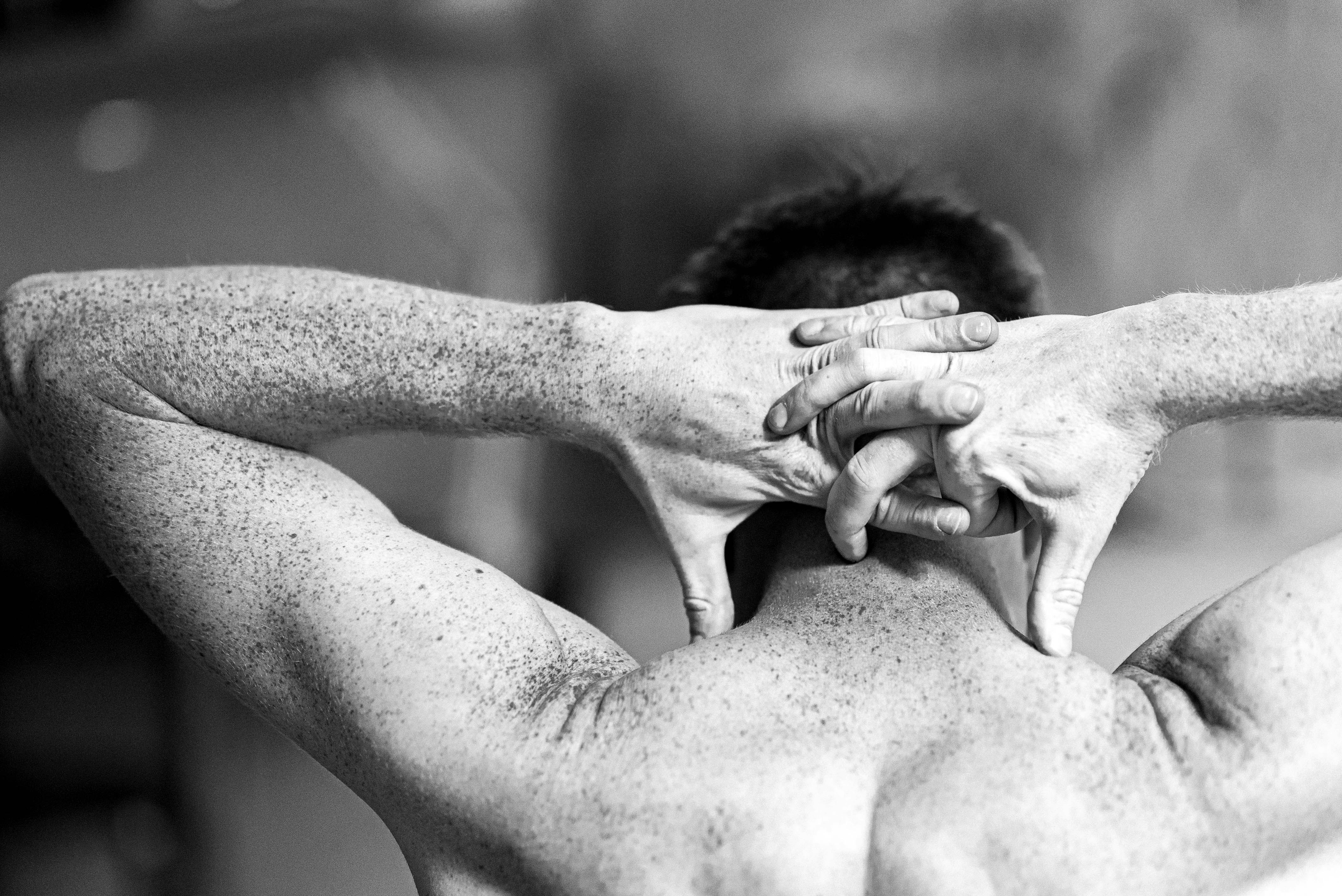 grayscale photo of man holding his head